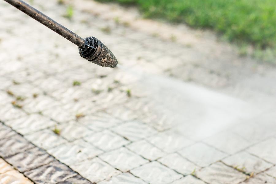 Close Up Photo Of A Cleaning A Tile Of Grass In His Yard. High P Close up photo of a cleaning a tile of grass in his yard. High pressure cleaning