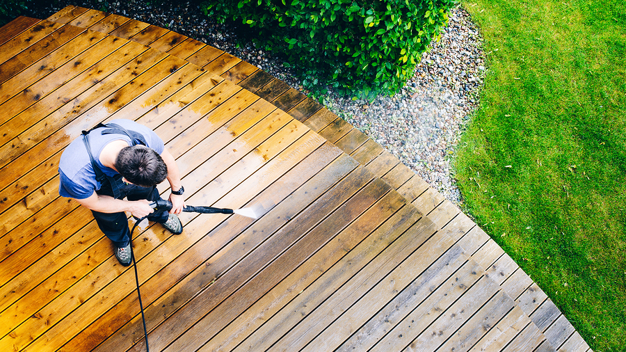 Cleaning Terrace With A Power Washer - High Water Pressure Clean cleaning terrace with a power washer - high water pressure cleaner on wooden terrace surface